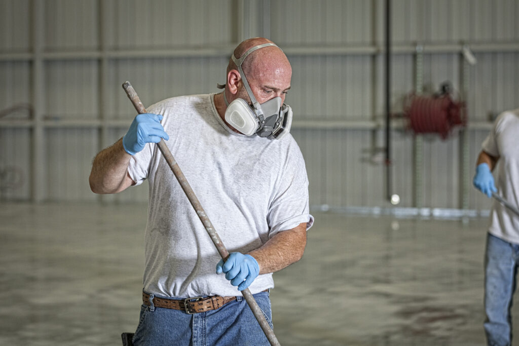 a worker wearing a protective face mask while working in an airport hanger
