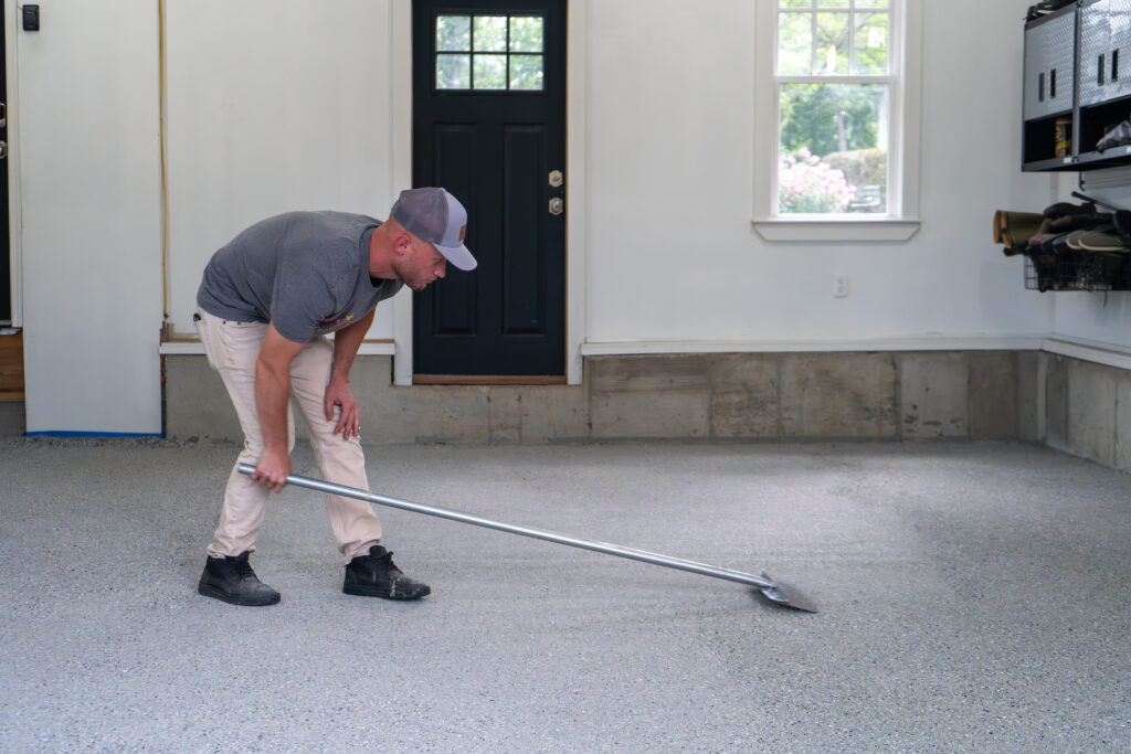 man working on a flake floor garage